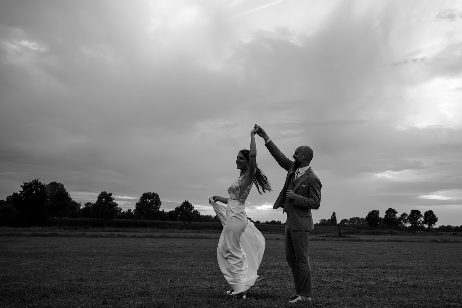 Bruidspaar danst tijdens zonsondergang