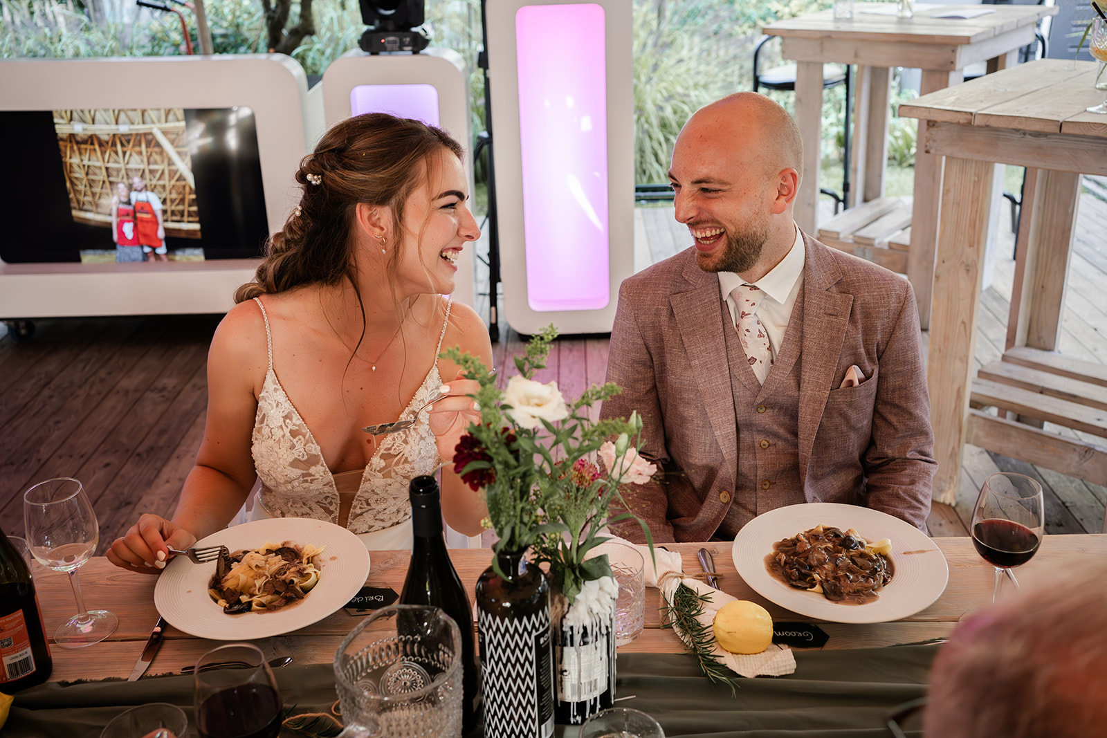 Bruidspaar kijkt elkaar vrolijk en verliefd aan voor het eten